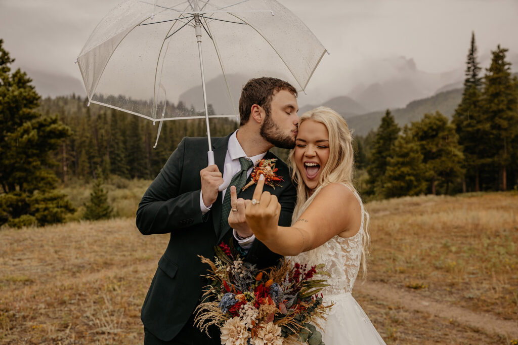 Wedding couple showing off their rings on rainy day.