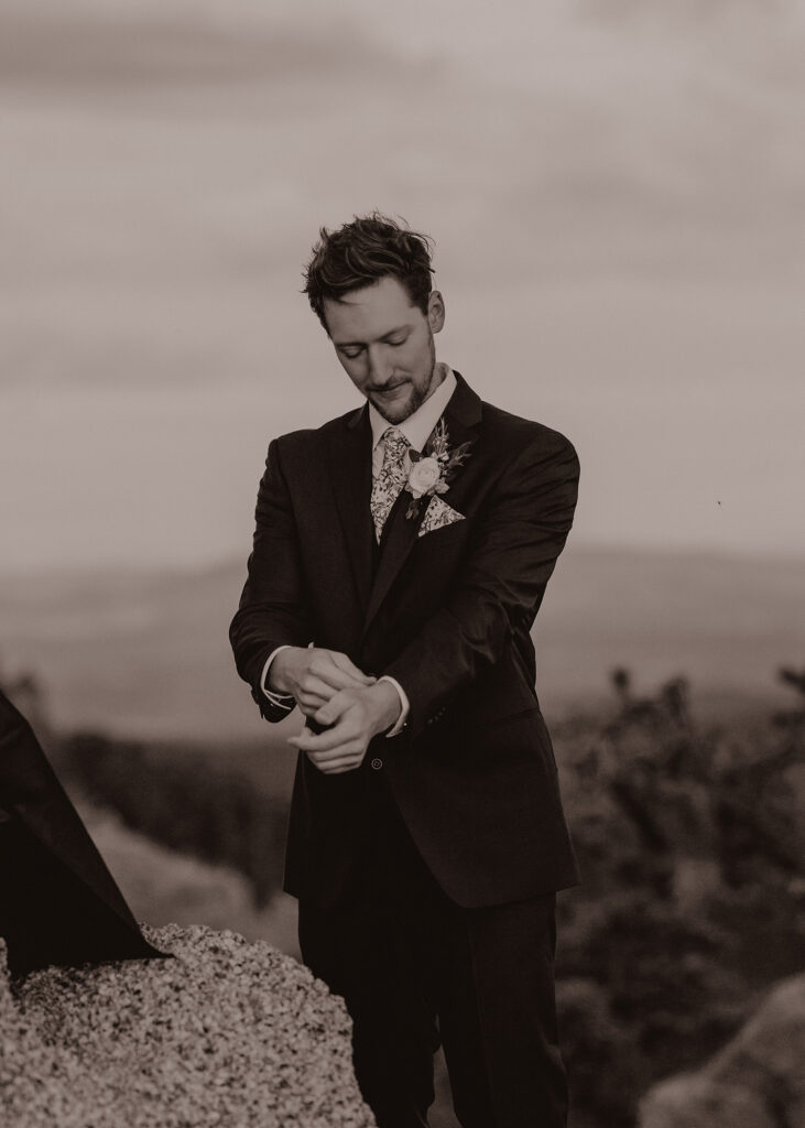 Groom adjusting sleeves on elopement suit.