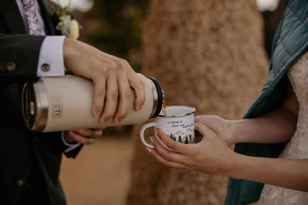 Groom pouring bride a cup of hot coffee in their custom elopement mugs.