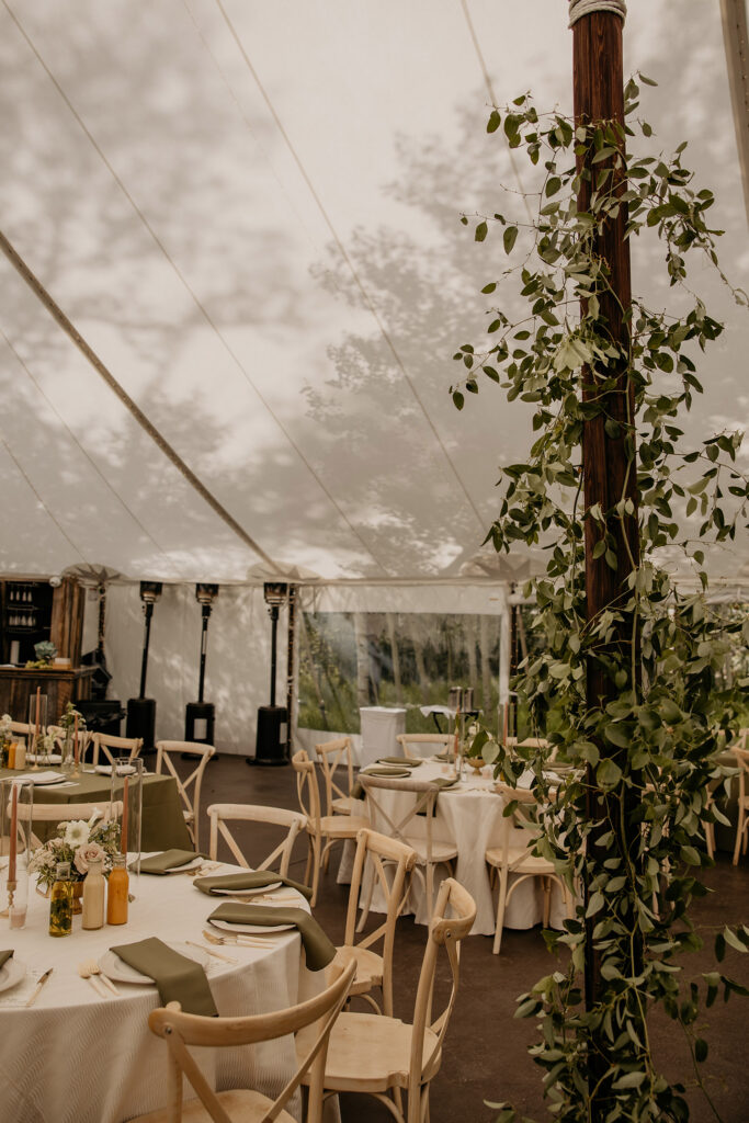 Wedding reception tables set up inside sailcloth tent at Blackstone Rivers Ranch.