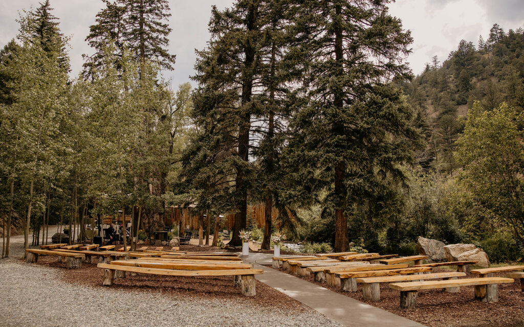 Ceremony site alongside river with log benches at Blackstone Rivers Ranch in Idaho Springs, Colorado.