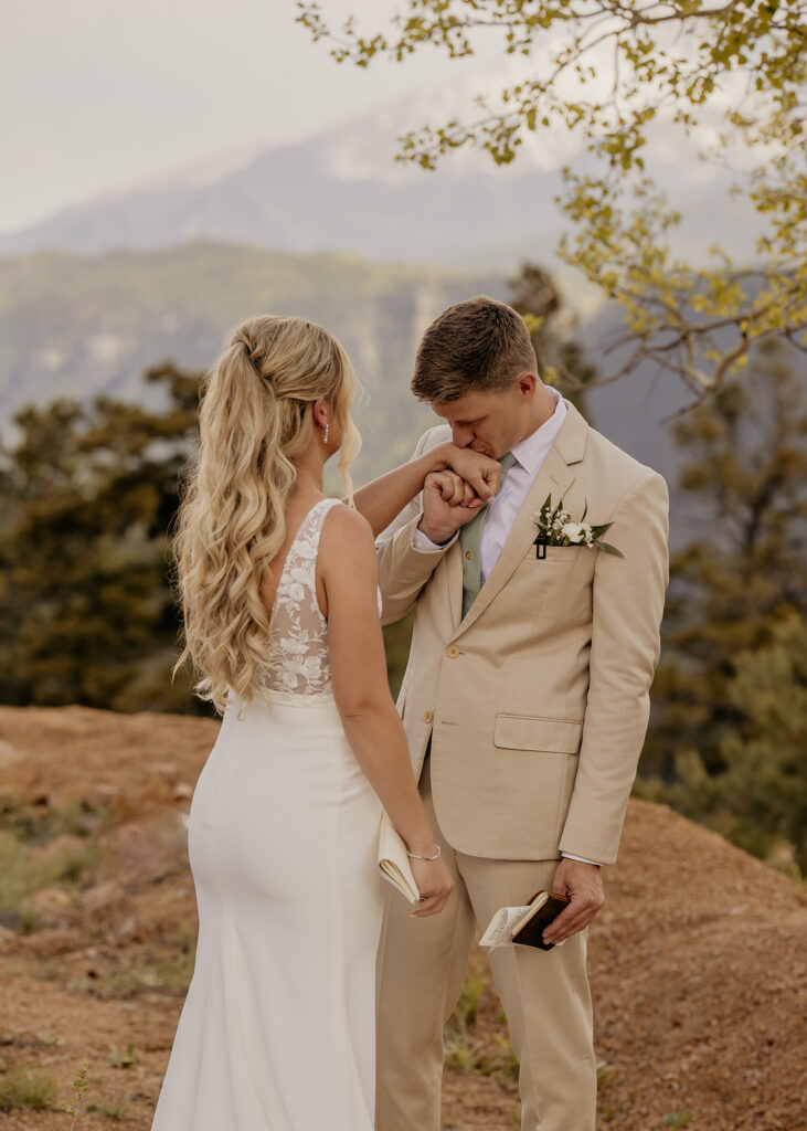 Groom kisses bride's hand after reading private vows.