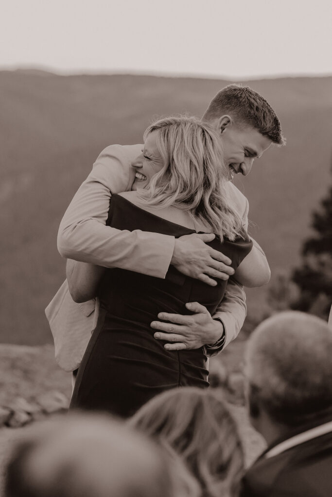 Groom hugs mother after walking down the aisle together.